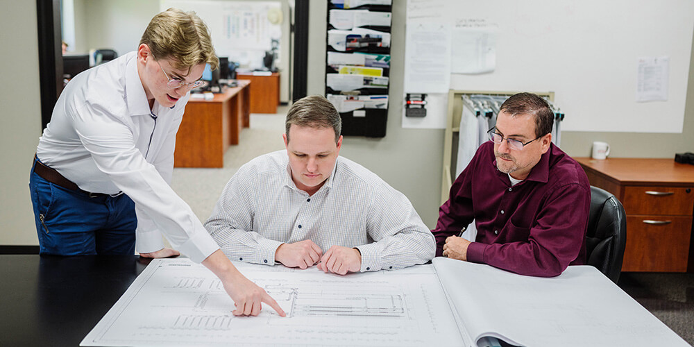 engineers in discussion while view drawings