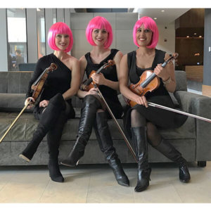 three string players with pink wigs