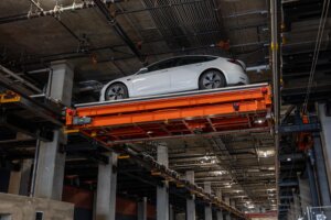 tesla transported on overhead automated parking system
